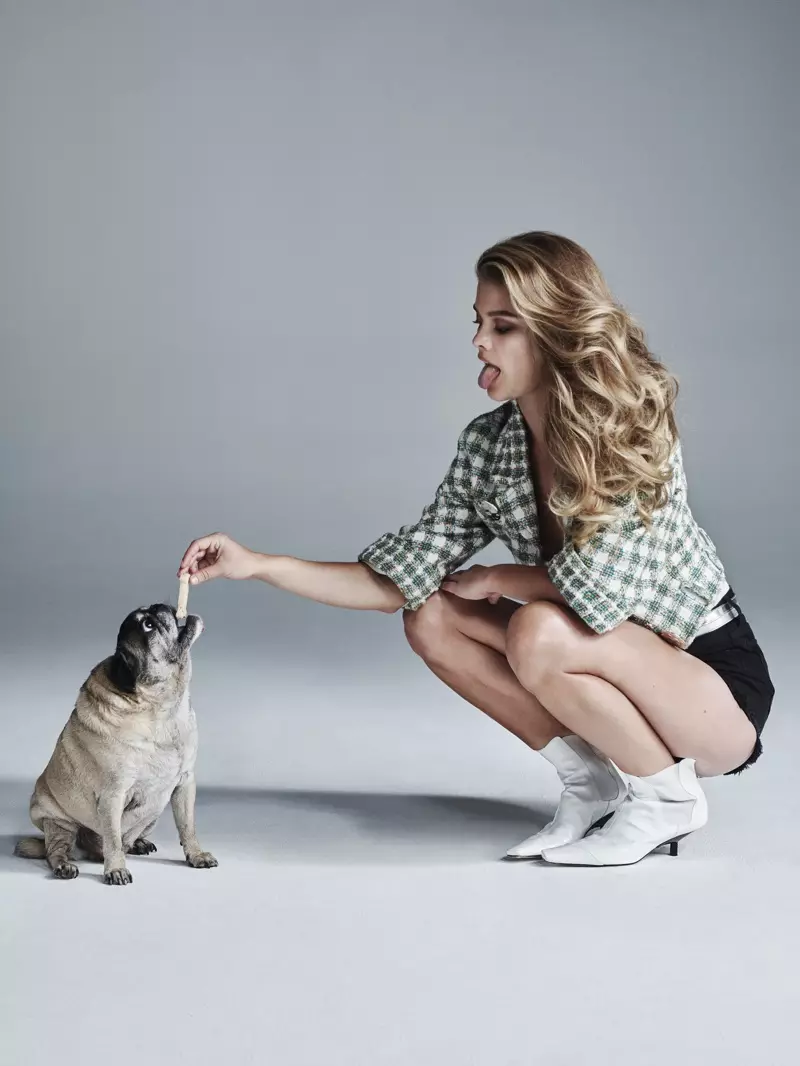 Nina Agdal bergabung dengan seekor anjing sambil mengenakan atasan dan ikat pinggang Chanel dengan celana pendek Denim x Alexander dan sepatu bot Loewe