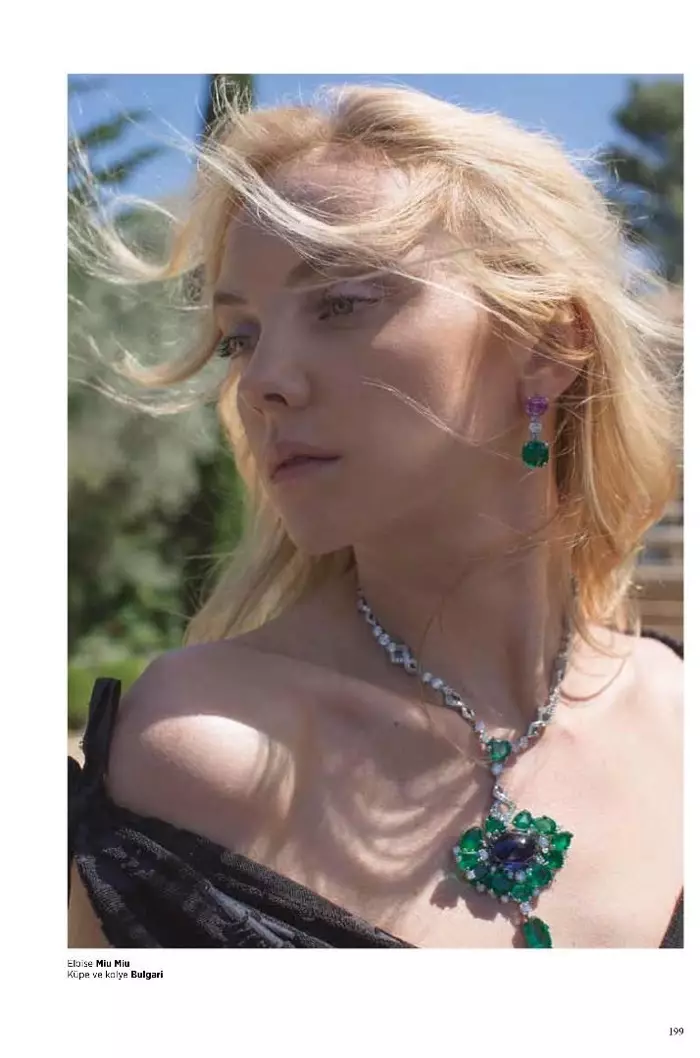 Das Model bekommt ihre Nahaufnahme in einem schulterfreien Kleid von Miu Miu und Schmuck von Bulgari