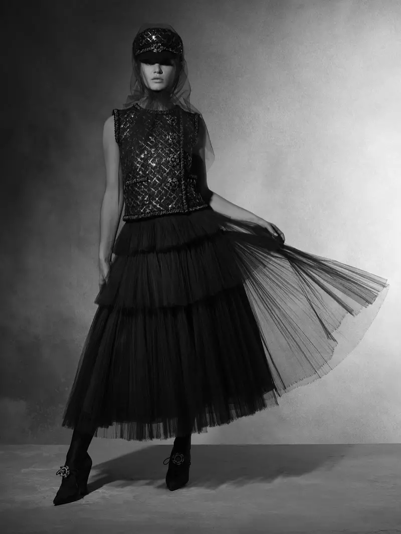 Modelis Anna Ewers dėvi siuvinėtą viršutinę dalį su daugiasluoksniu sijonu iš Chanel 2018 m. rudens kolekcijos