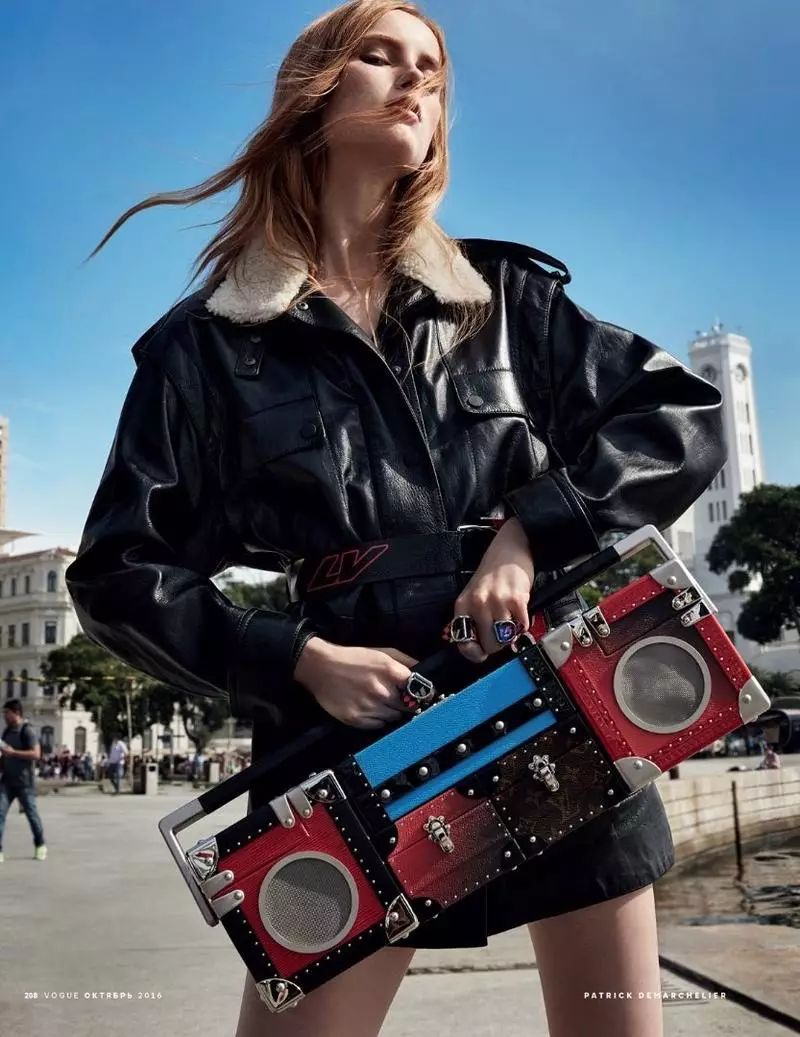 Mae'r model yn ystumio mewn siaced ledr Louis Vuitton a bag Boombox