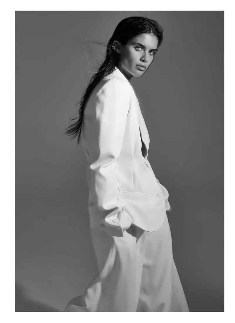 Загвар өмсөгч Сара Сампайо Майкл Корс цуглуулгаас цагаан хүрэм, өмд өмссөн костюмтай