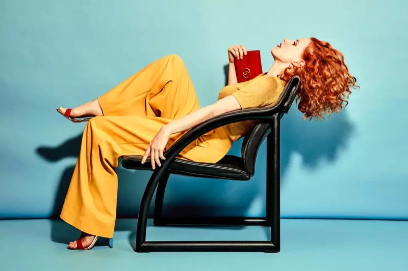 Jessica Chastain sitzt auf einem Stuhl und trägt ein T-Shirt von Missoni, eine Hose von Tibi, Sandalen von Giuseppe Zanotti und eine Umhängetasche von Gucci