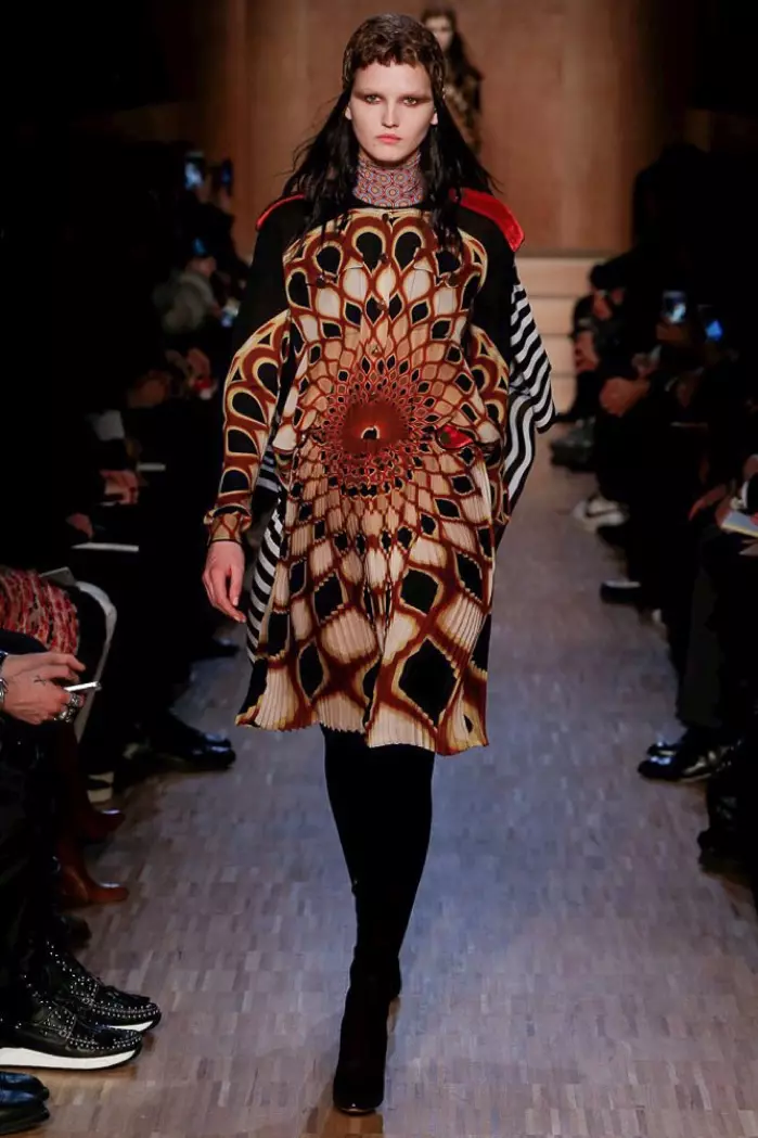 Modelka chodzi po wybiegu na pokazie Givenchy jesień-zima 2016 w sukience z długimi rękawami we wzorzyste wzory
