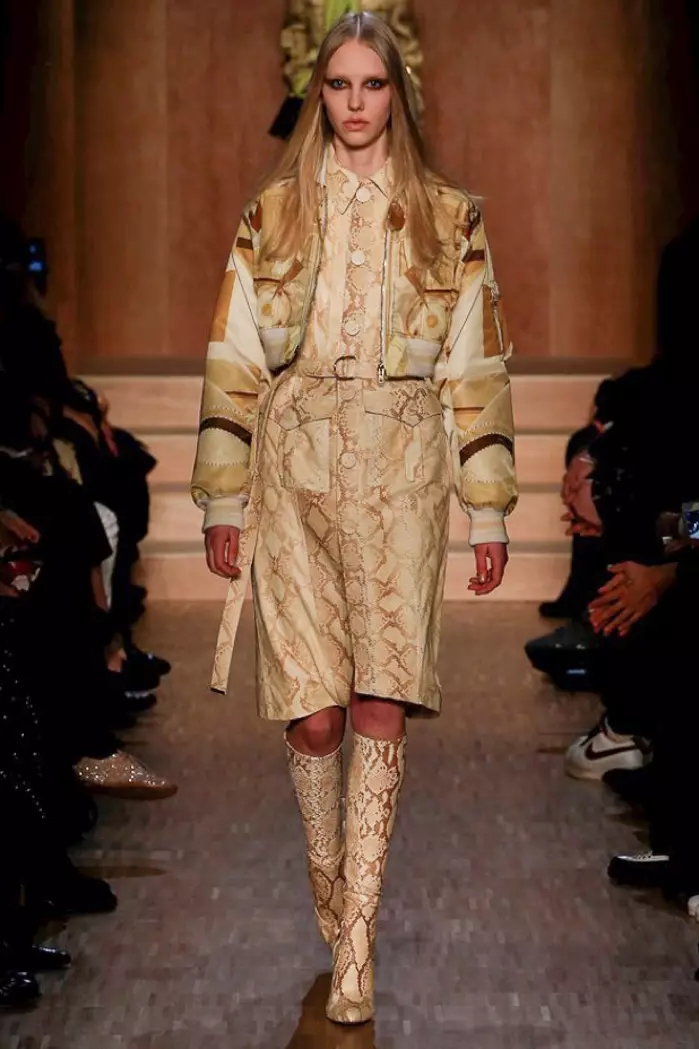 Modelka spaceruje po wybiegu na pokazie Givenchy jesień-zima 2016 w przyciętej kurtce bomber, sukience w pytona i butach do kolan