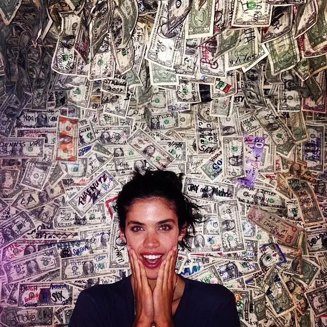 Sara Sampaio pozuje przy ścianie pieniędzy