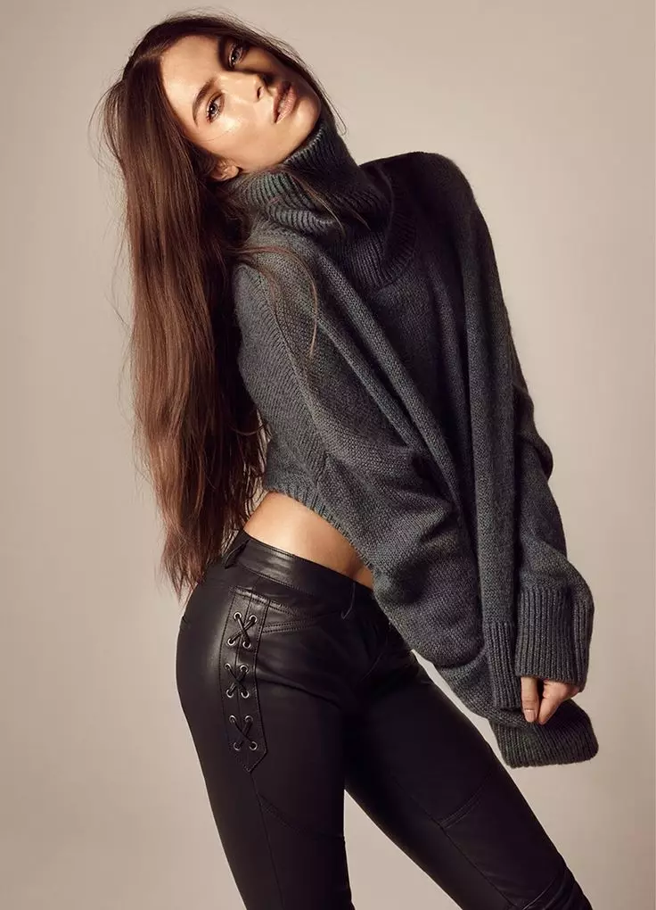 Jessica poseert in een antracietgrijze trui en slim-fit broek