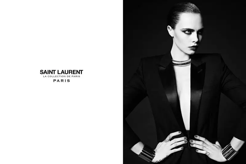 Qo'llarini beliga qo'ygan holda suratga tushayotgan Kara Delevin Saint Laurent's Parij kolleksiyasidan smoking ko'ylagi modelini yaratmoqda.