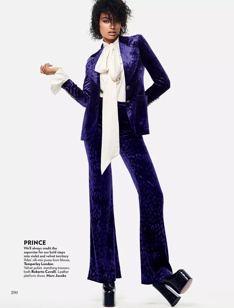 Channeling Prince, Kelly Gale çakêt û pantolonên qedifî yên binefşî ji Roberto Cavalli li xwe dike.