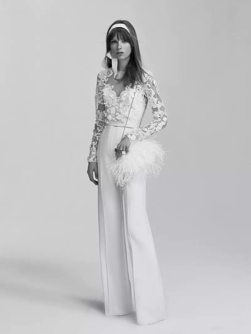 Ένα μοντέλο φοράει μια λευκή στολισμένη, φαρδιά ολόσωμη φόρμα από τη συλλογή νυφικών την άνοιξη 2017 της Elie Saab
