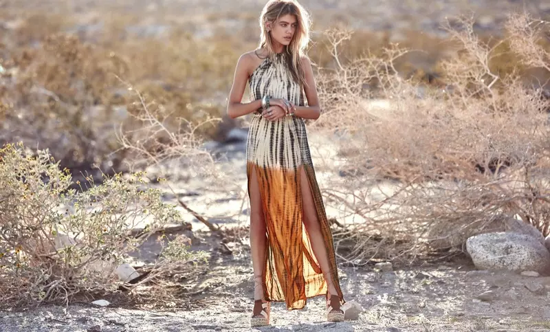 La bionda modella un vestito lungo con scollo all'americana con 2 spacchi