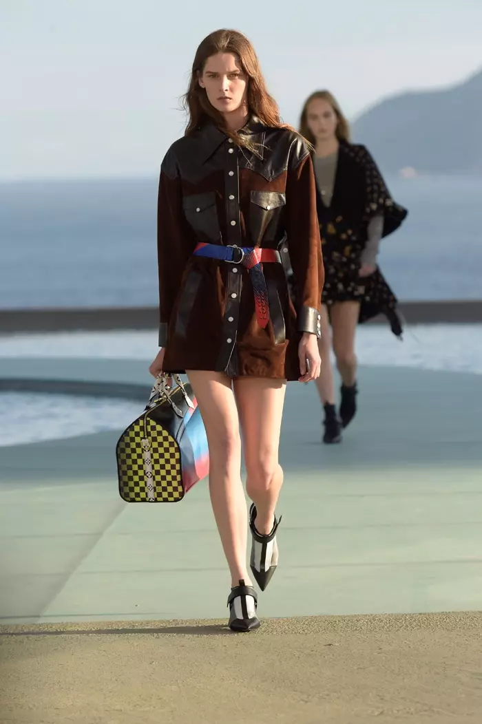 Seorang model berjalan di landasan di pameran resort Louis Vuitton 2017 memakai jaket bertali pinggang