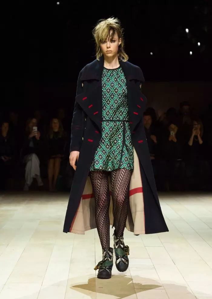 Edie Campbell rint de lâningsbaan by Burberry's hjerst-winter 2016-show mei in militêre jas en metallysk diamantjacquard plooide shirtjurk