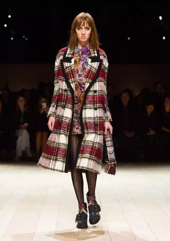 Modelo desfila na passarela do desfile outono-inverno 2016 da Burberry vestindo um casaco xadrez e um vestido jacquard floral rosa