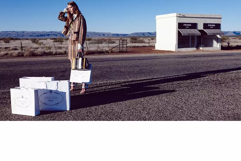 La model posa al costat d'una botiga de Prada amb una faldilla jaqueta de ratlles, també de Prada