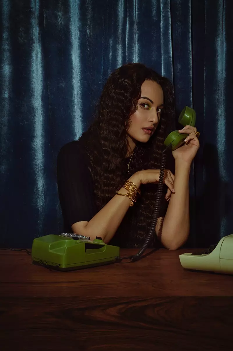 Retro bir telefonla poz veren Sonakshi Sinha, bir telefon görüşmesi yapıyor.