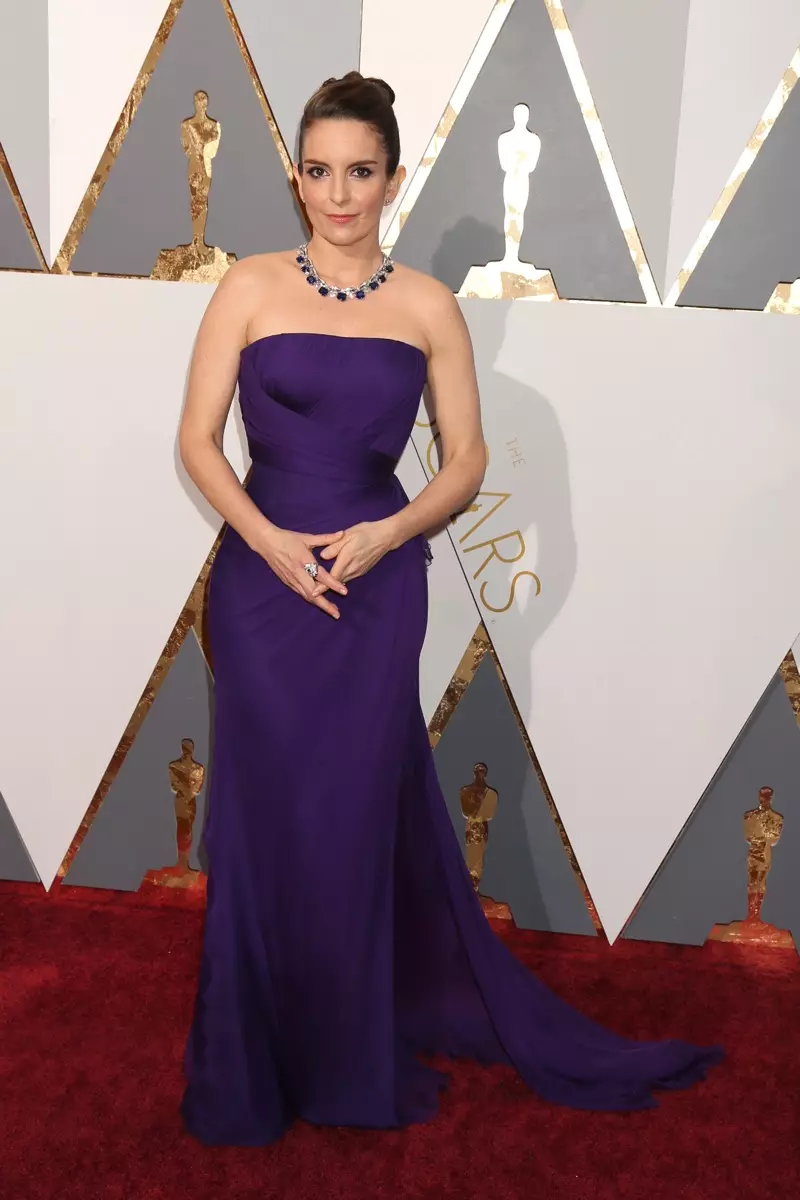 Tina Fey lọ si Oscars 2016 ti o wọ aṣọ ẹwu Versace ti ko ni okun ni eleyi ti pẹlu awọn ohun ọṣọ Bulgari. Fọto: Helga Eseb / Shutterstock.com