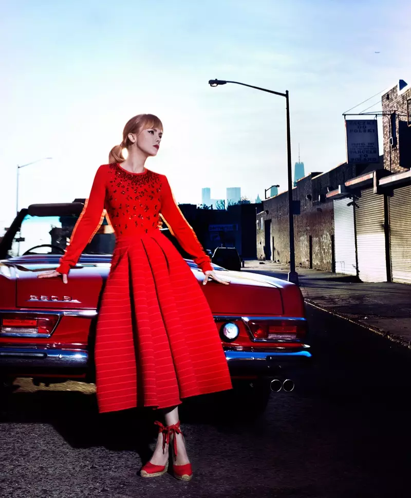 Christina Ricci, wat langs 'n vintage Mercedes-Benz poseer, modelleer 'n rooi langmou-pas- en flikkerrok