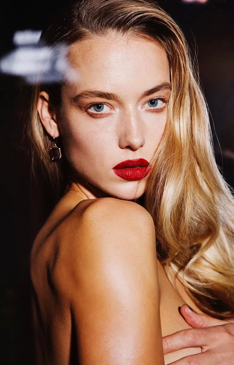 La modella porta i suoi capelli in onde glamour con una sfumatura di rossetto rosso sirena