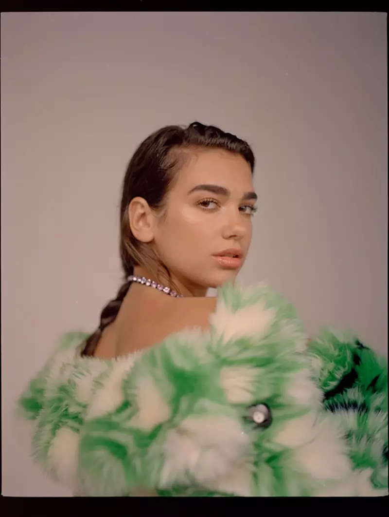 Dua Lipa je videti glamirana in nosi plašč iz umetnega krzna Miu Miu in ogrlico Ashley Williams