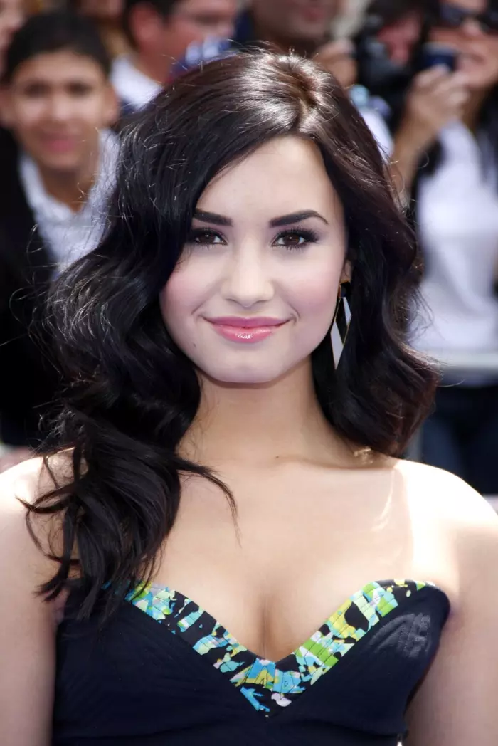 Demi Lovato nuduhake gaya rambut sing dawa lan bergelombang kanthi warna coklat sing luwih peteng ing premiere film 2010. Foto: Tinseltown / Shutterstock.com