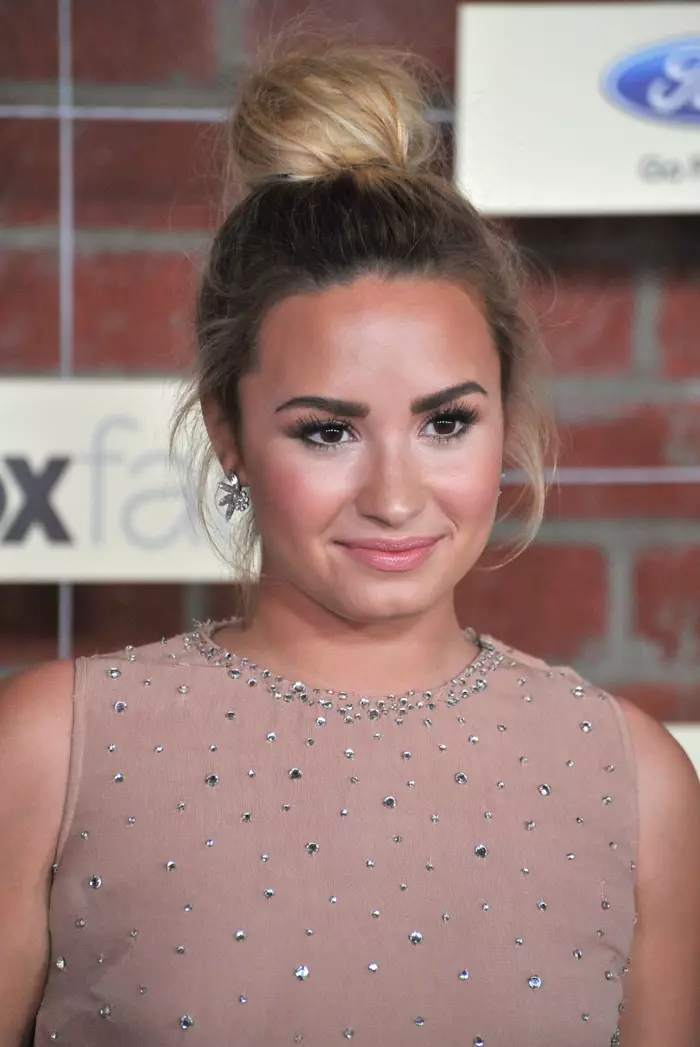 Demi Lovato uga nganggo rambute ing gaya rambut simpul ndhuwur ing 2012 minangka pirang. Foto: Featureflash / Shutterstock.com