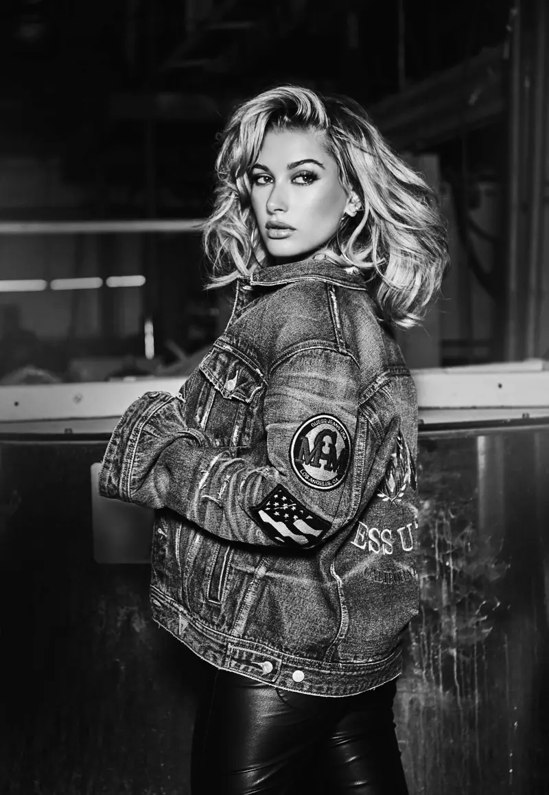 Modela Hailey Baldwin çakêtê denîmê yê Guess-ê bi pantolonên çermî li xwe dike.