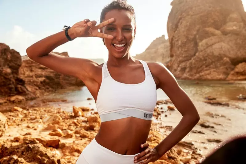 Jasmine Tookes zeigt ein Piece-Schild und posiert für Victoria Sport