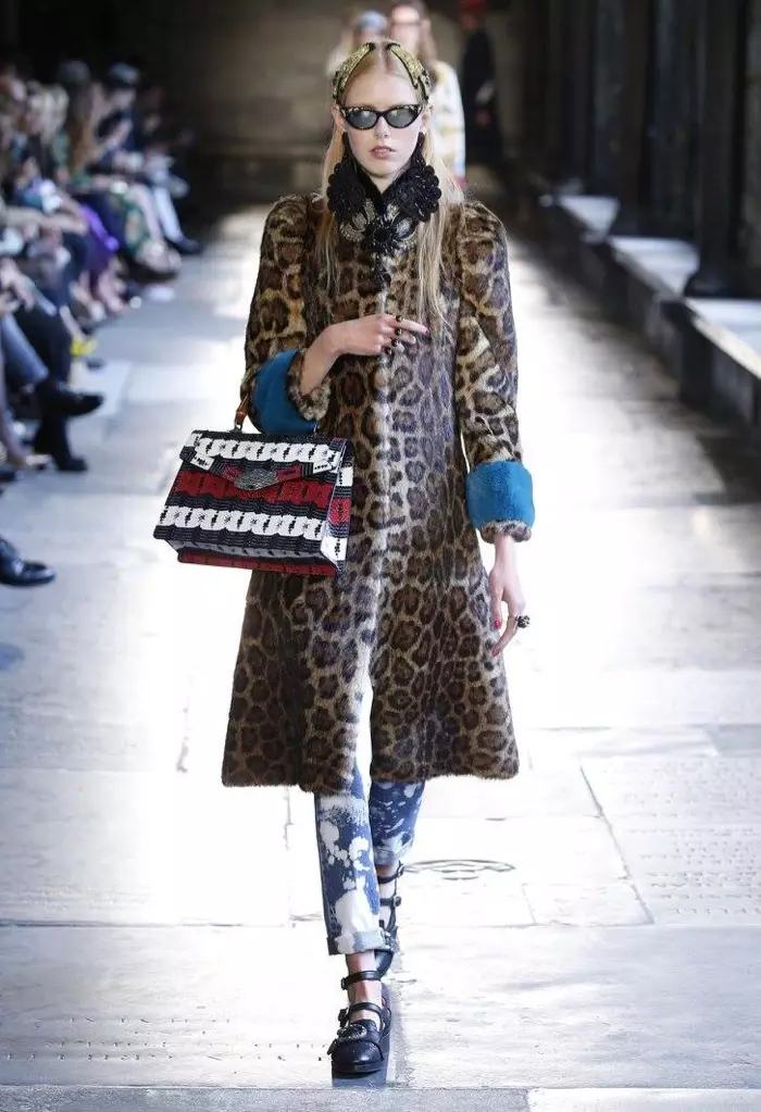 E Modell trëppelt d'Piste beim Gucci's Resort 2017 Show mat engem Leopard-Pelzmantel a gebleechtem Denim Hosen