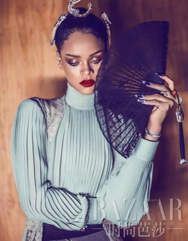 En blå bluse og vifte er modelleret af Rihanna for Bazaar China.