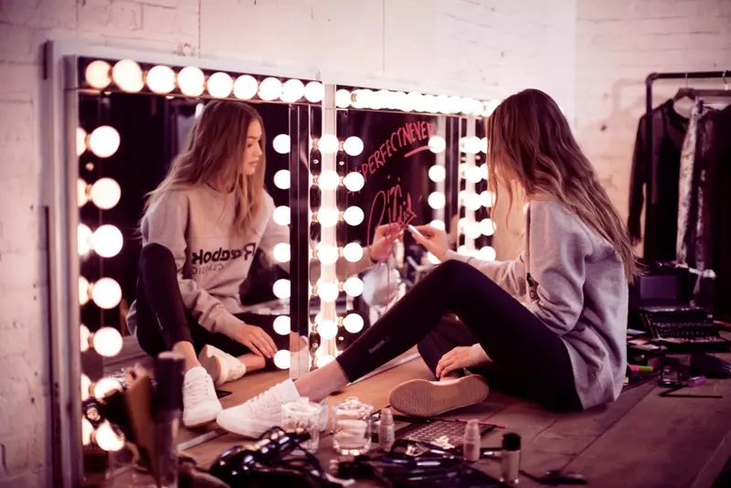 Écrivant dans un miroir, Gigi Hadid écrit le slogan #PerfectNever de Reebok