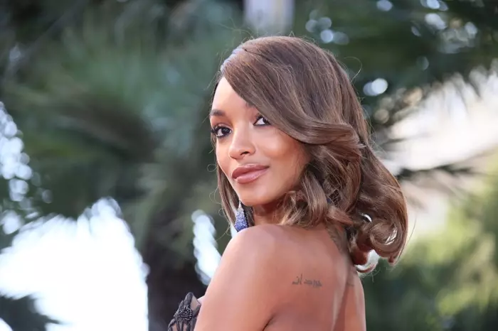 Jourdan Dunn yana sanye da madaidaicin curls tare da ɓangaren gefe. Hoto: Denis Makarenko / Shutterstock.com