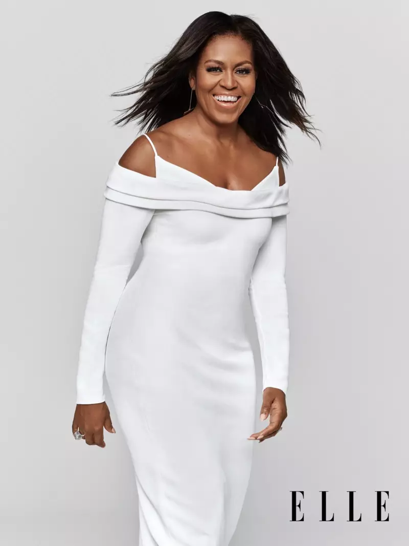 Agus gúna Cushnie agus cluaise Jenny Bird á caitheamh aici, tá meangadh gáire ar Michelle Obama