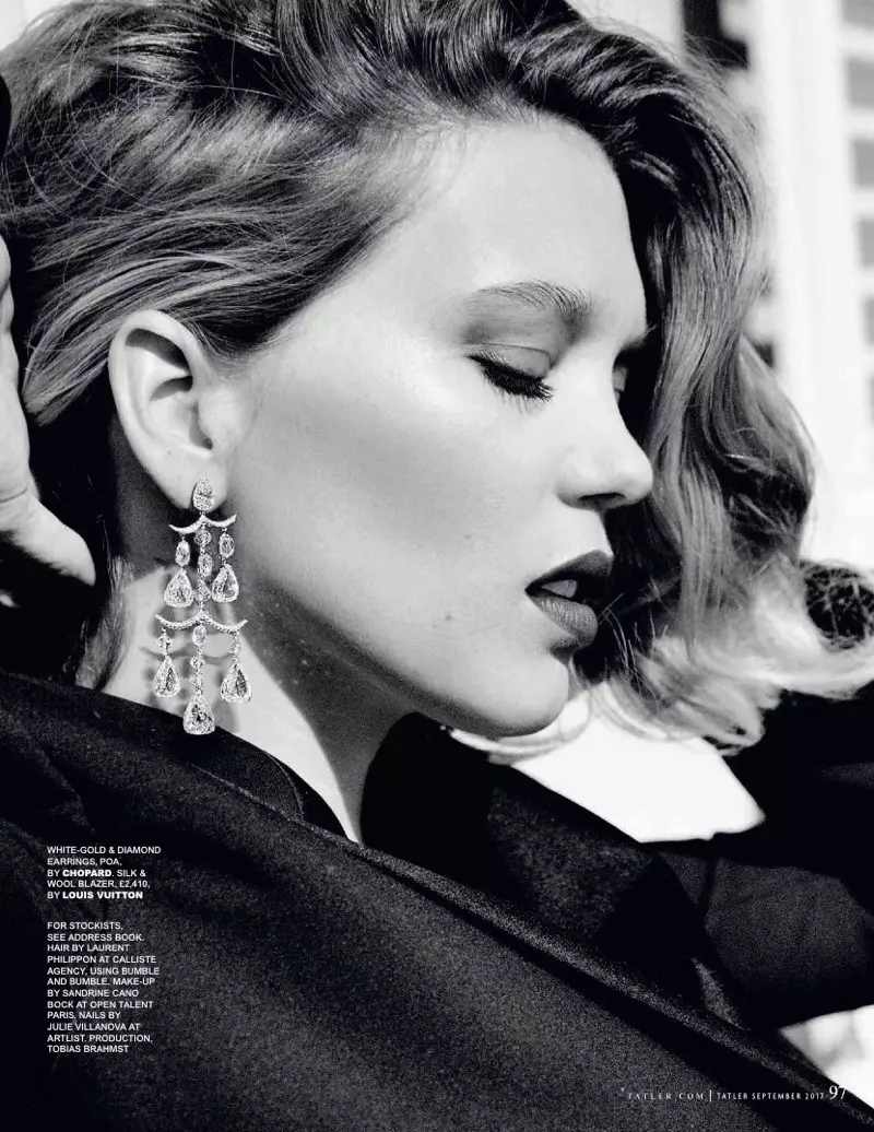 黑白照片，Lea Seydoux 身著 Louis Vuitton 西裝外套和 Chopard 耳環