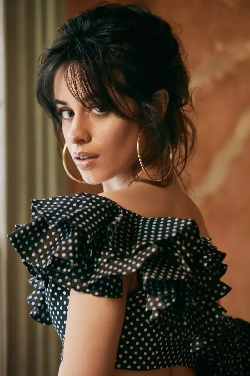 Camila Cabello ina seasamh i mbarr ruffled Zimmermann agus cluaise Jennifer Fisher