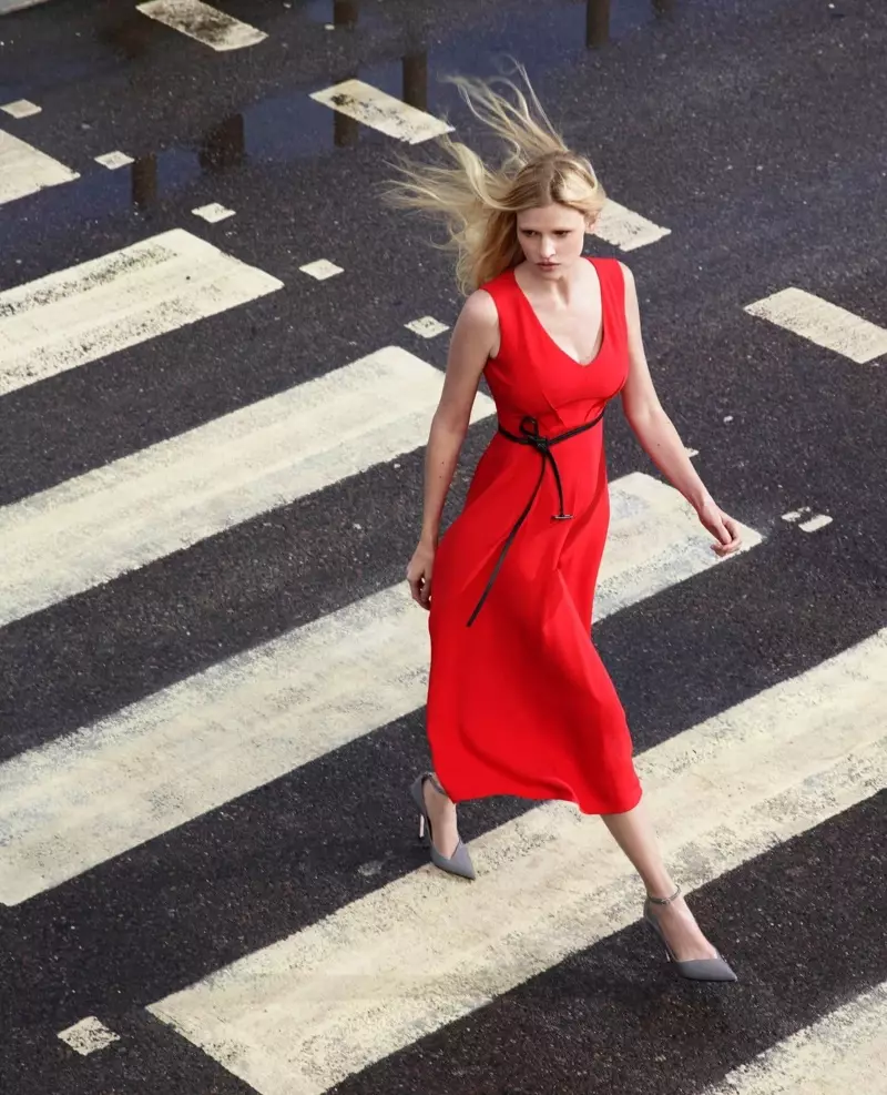 Lara Stone, ganz in Rot gekleidet, steht vor der Kampagne von Alessandro Dell’Acqua X Elena Mirò.