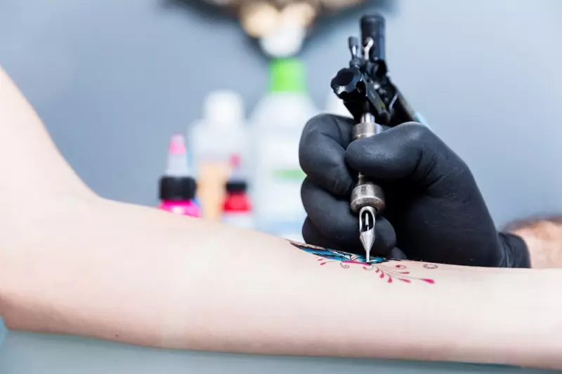 Mulher recebendo tatuagem de borboleta no braço